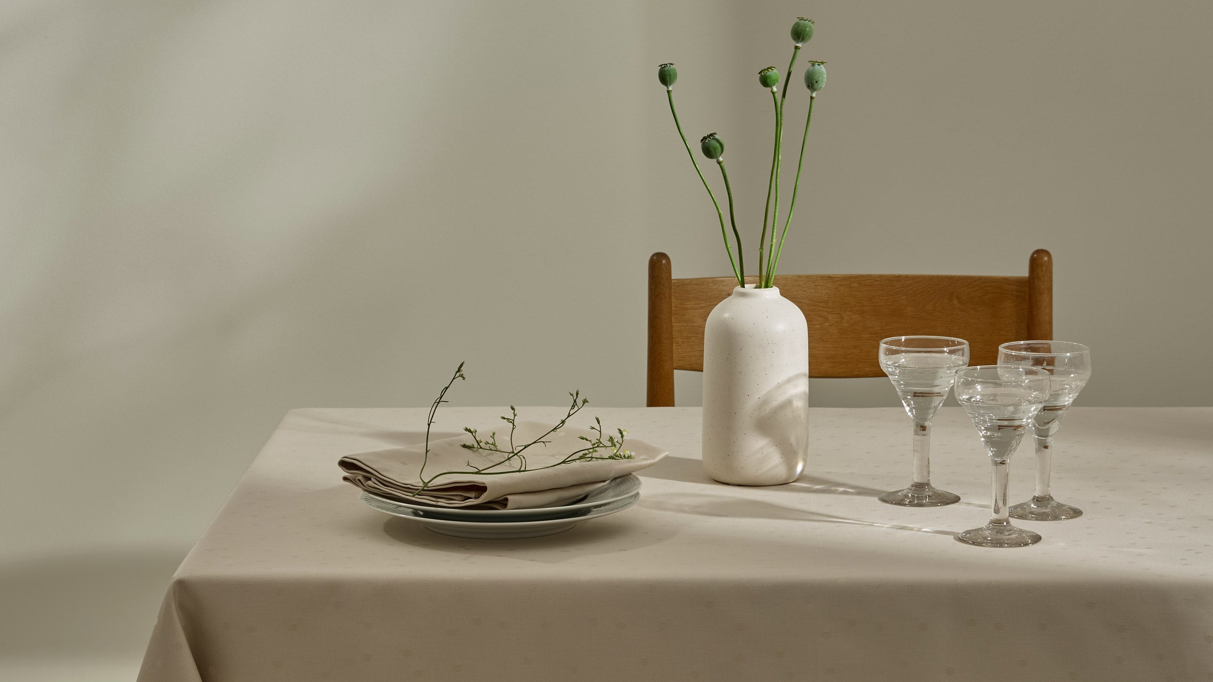 Bord dækket med damaskdug, en tallerken med en serviet på